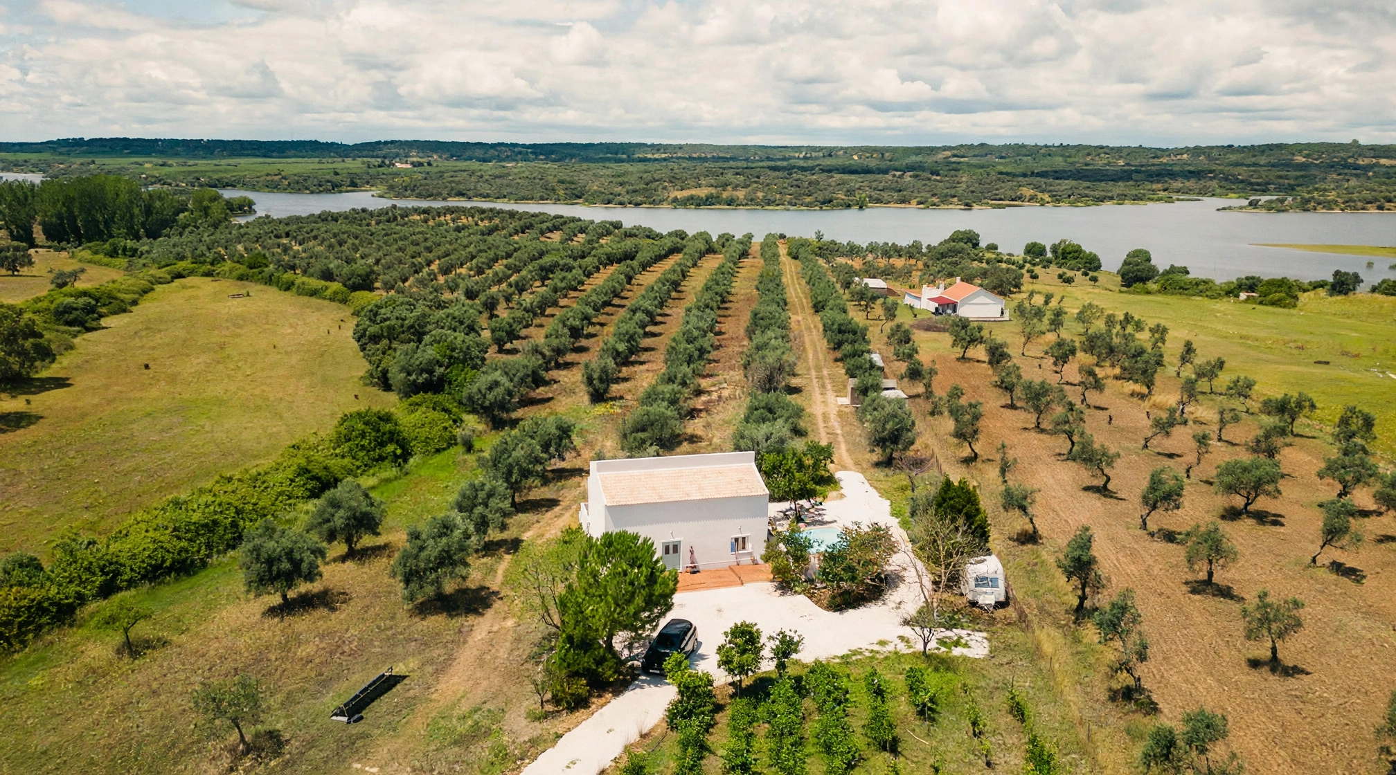 Vista aérea da casa MonteZinho, rodeada pelo olival e junto à albufeira