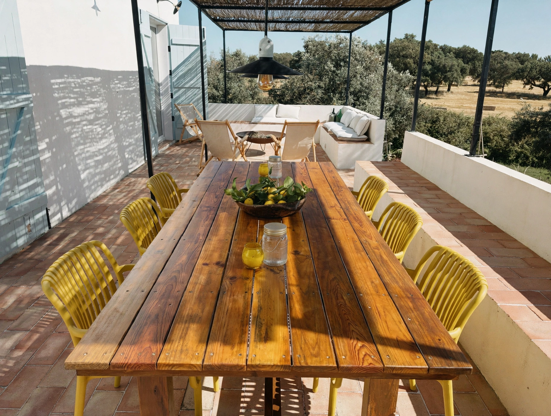 Mesa posta no terraço da casa MonteZinho, com cadeiras amarelas